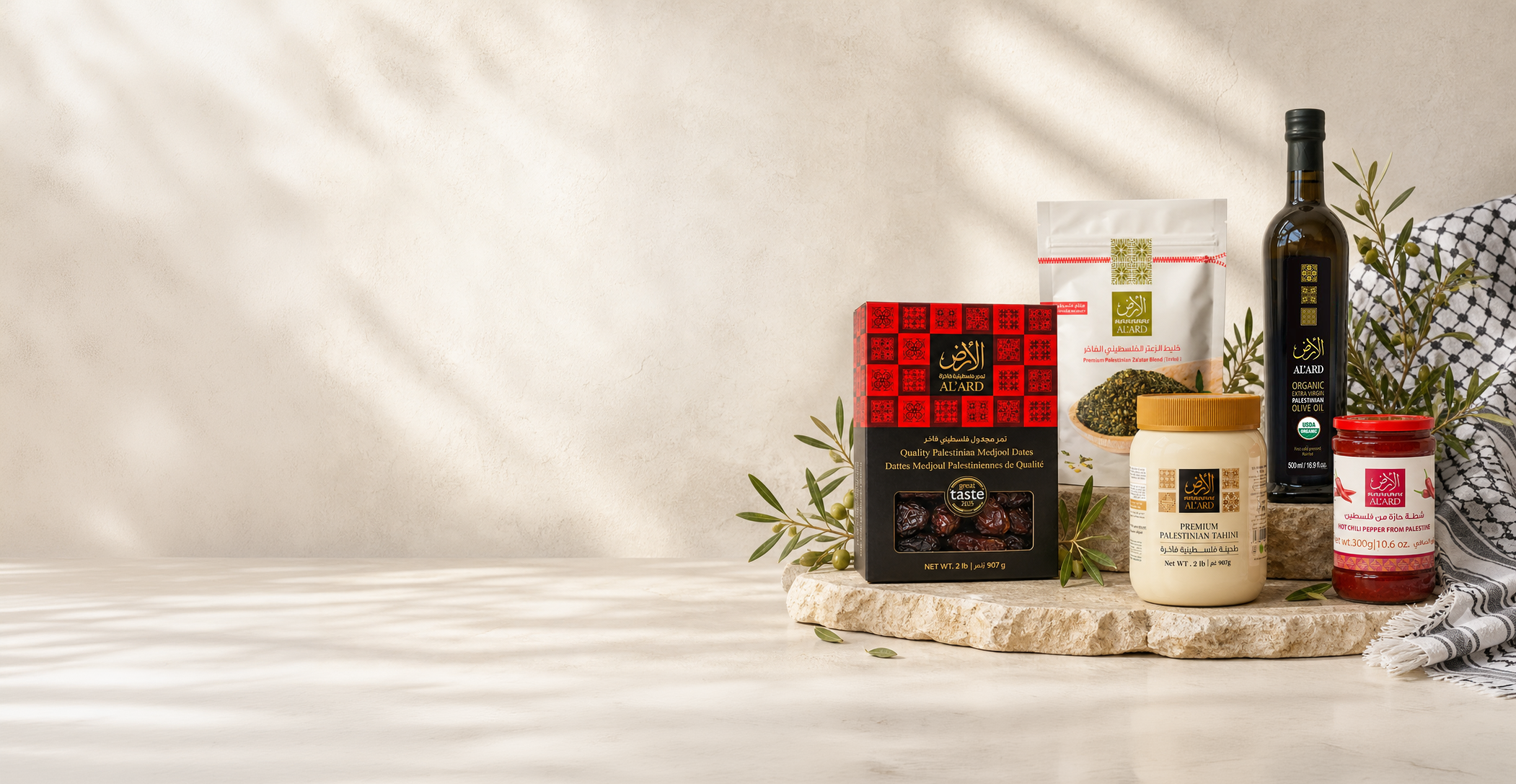 Al’Ard Palestinian products arranged with olive branches and a kufiya